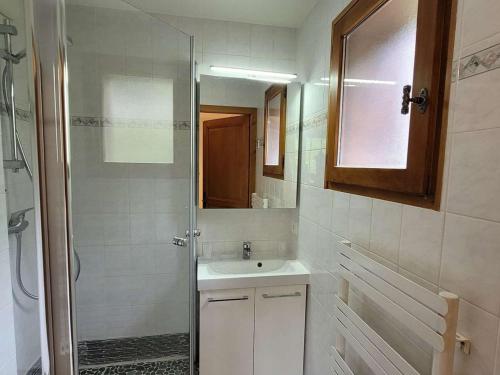 une salle de bain avec une douche, un lavabo et un miroir dans l'établissement Spacieux T4 avec garage et parking au Grand-Bornand - 6 pers - FR-1-458-201, au Grand-Bornand
