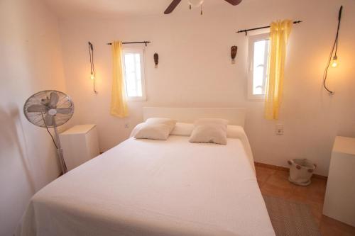 Cama blanca en habitación con 2 ventanas en Catalunya Casas Incredible & Unique Costa Dorada Abode!, en Creixell