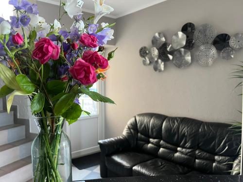 a vase of flowers on a table in a living room at Готель «У Батька» in Truskavets