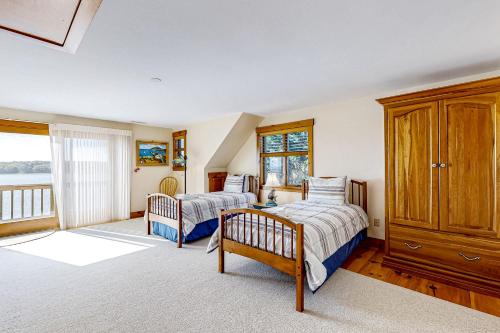 ein Schlafzimmer mit zwei Betten und einem großen Fenster in der Unterkunft Cape Springs Cottage in Chatham