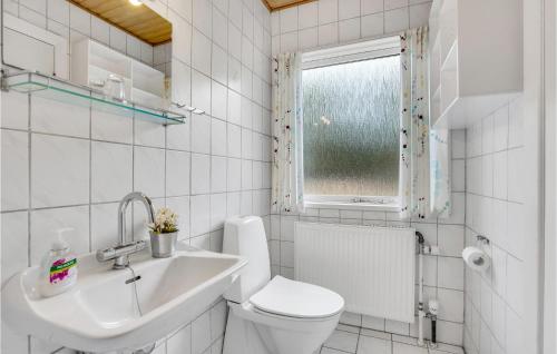 baño con aseo y lavabo y ventana en Pjank, en Vejers Strand