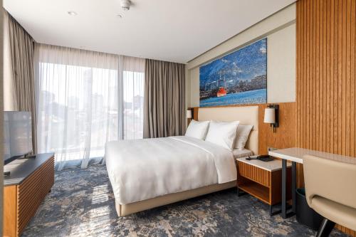 a hotel room with a bed and a television at Piazza Epigraph in Batumi