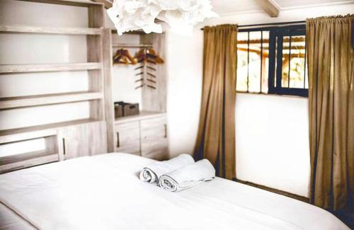 - une chambre avec un lit blanc et une fenêtre dans l'établissement Ti Bout Paradi Ti Zil, à Tamarin
