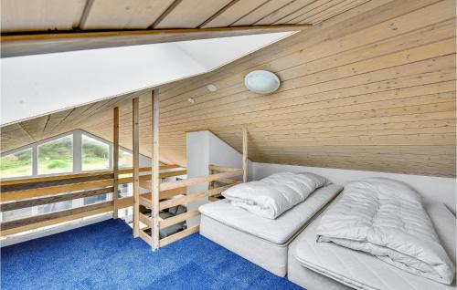 a bedroom with a bed and a wooden wall at 3 Bedroom Amazing Home In Hvide Sande in Havrvig