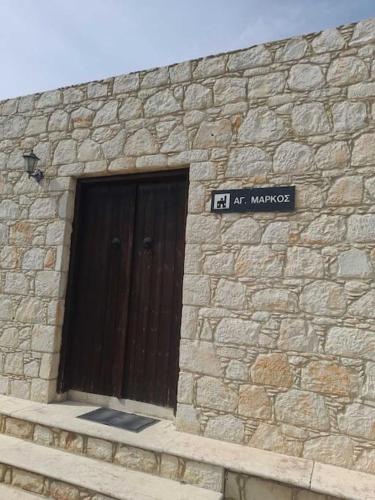 a stone building with a door and a sign on it at Ivi's House Giolou in Paphos City