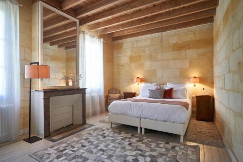 1 dormitorio con 1 cama grande y chimenea en Château Bonalgue - Pomerol en Libourne