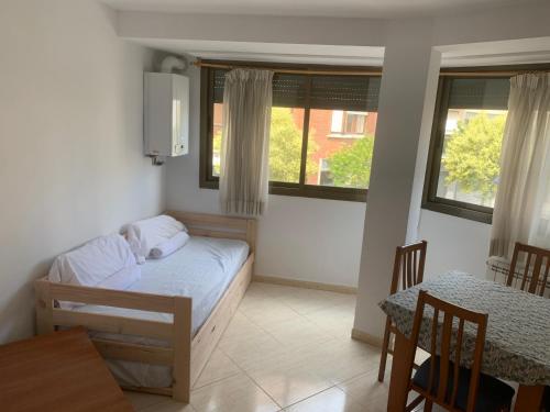 Habitación pequeña con cama, mesa y sillas en Oliva Mar, en Lloret de Mar