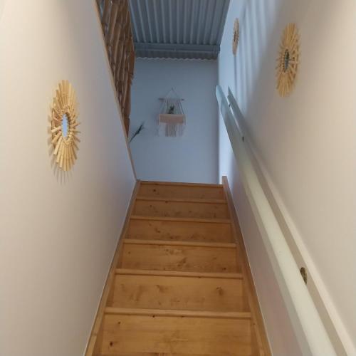 a staircase with white walls and wooden floors at Gite dans une ancienne corps de ferme C in Provins