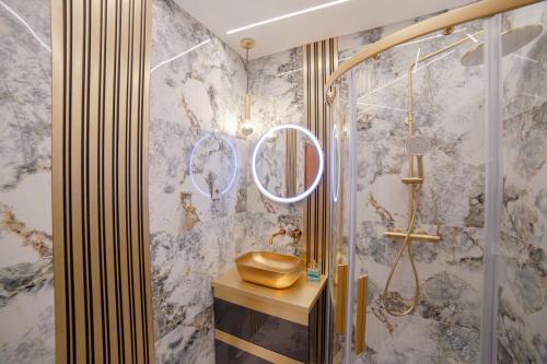 y baño con lavabo de oro y ducha. en Duplex Penthouse Aparthotel Rosa en Podčetrtek