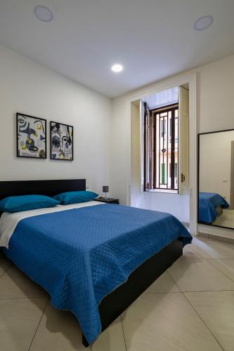 a bedroom with a blue bed and a window at Casa Vacanze Nemesi AURA in Salerno