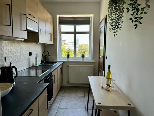 - une cuisine avec une table et une bouteille de vin dans l'établissement Apartament pod Czerwonym Pagajem Gdynia, à Gdynia