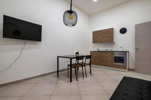 a living room with a table and a tv on a wall at Casa Vacanze Nemesi AURA in Salerno