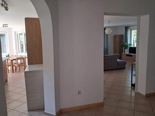 a kitchen and living room with a couch and a table at Pluski Dom PROJEKT PLUSKI nad Jeziorem Pluszne in Pluski