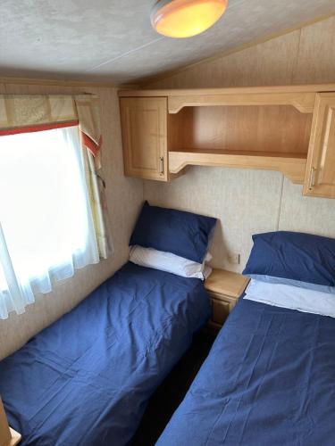 a small room with two beds and a window at The Paddock View at Danebury in Stockbridge