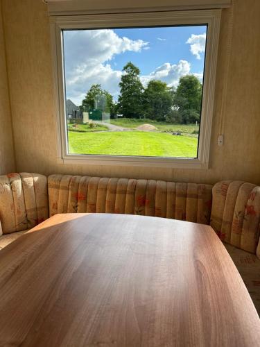 a table in a room with a large window at The Paddock View at Danebury in Stockbridge
