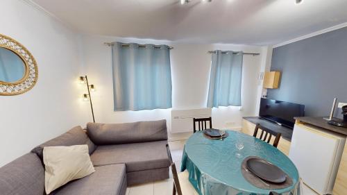 un salon avec un canapé et une table dans l'établissement Ravissant Duplex Intra-Muros, à Avignon