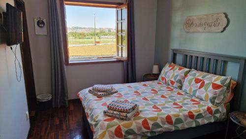 a small bedroom with a bed and a window at Beachwalk guesthouse in Esmoriz