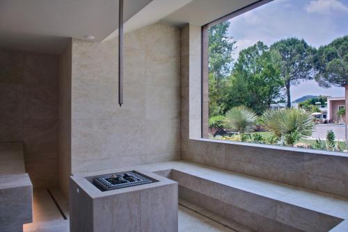 a room with a window and a bench with a stove at Hotel Mioni Pezzato in Abano Terme