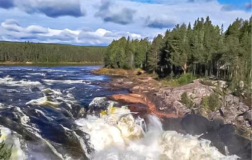 a river with rapids on the rocks and trees at Lovely Home In Överkalix With Sauna in Överkalix