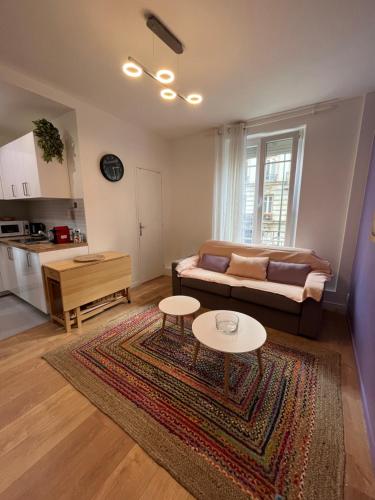 un salon avec un canapé et une table dans l'établissement Pretty Purple, à Clichy