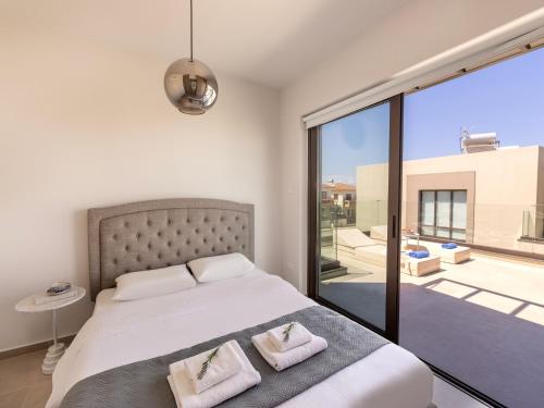 een slaapkamer met een groot bed met twee kussens bij Malama Villas by Karma in Paralimni