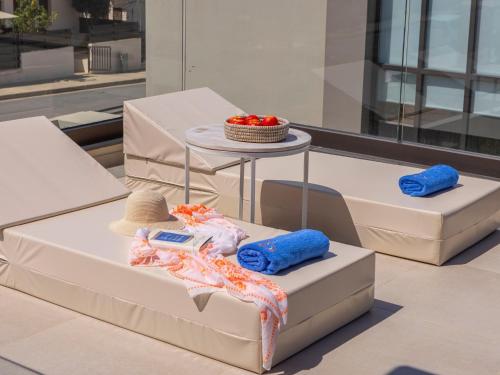 twee bedden met handdoeken en een hoed op een tafel bij Malama Villas by Karma in Paralimni