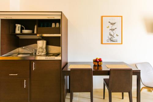 a kitchen and dining room with a table and chairs at Cosmos Hotel in Rethymno Town