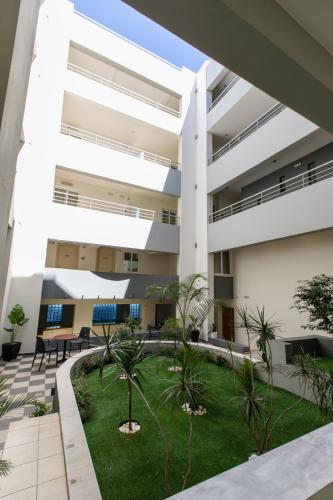 an apartment building with a courtyard with palm trees at Cosmos Hotel in Rethymno Town