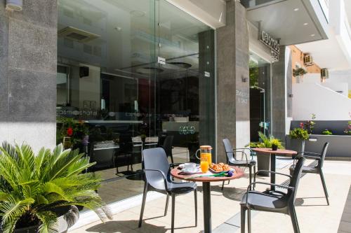 un patio con mesas y sillas en un restaurante en Cosmos Hotel, en Rethymno