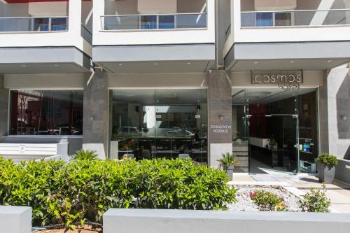 una fachada de un edificio con arbustos delante de él en Cosmos Hotel, en Rethymno