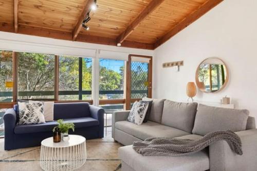 托基Sunset Sanctuary 500m to beach Pet Friendly的客厅里有一张沙发和一张桌子。