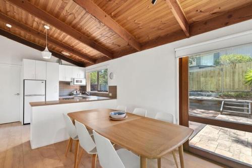 a kitchen and dining room with a wooden table and chairs at Sunset Sanctuary 500m to beach Pet Friendly in Torquay