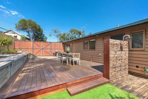 a deck with a table and chairs on a house at Sunset Sanctuary 500m to beach Pet Friendly in Torquay