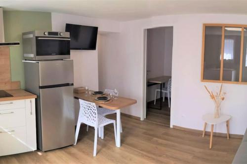 une petite cuisine avec une table et un réfrigérateur dans l'établissement T1 bis proche Marais avec garage à moto, à Bourges