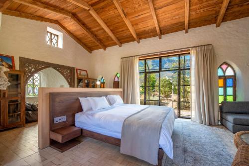 a bedroom with a bed and a large window at La Villa in Franschhoek