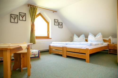 Un dormitorio con dos camas y una ventana. en Penzion Soltis, en Liptovské Revúce
