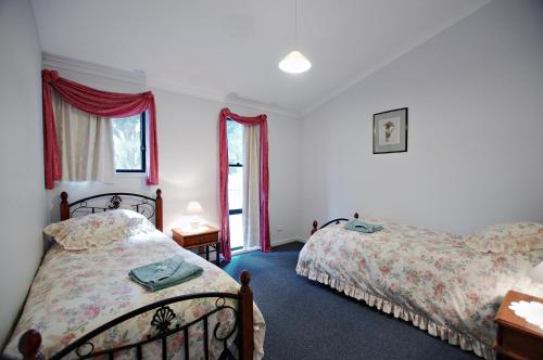 1 dormitorio con 2 camas y ventana en Serenity Grove, en Broke