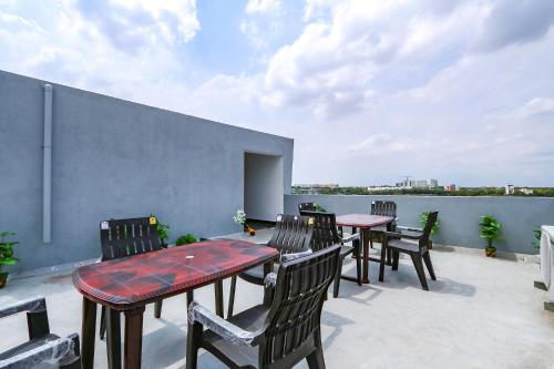 a patio with tables and chairs on a roof at FabHotel VKs - Nr UMCC Shahpur, Jeedimetla in Hyderabad
