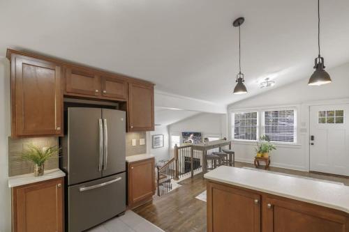 een keuken met houten kasten en een roestvrijstalen koelkast bij 2BR 2Bath Chamblee Brookhaven Ashford Park Brand new furnishings throughout in Atlanta