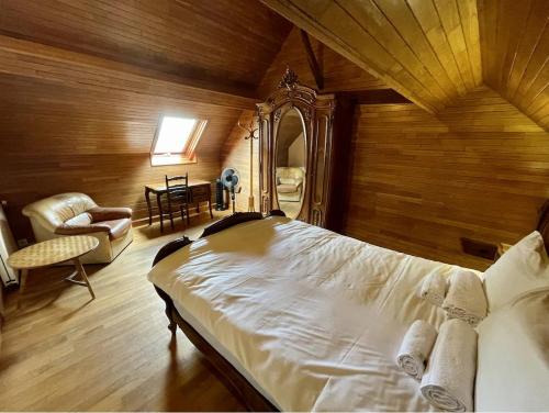 une chambre avec un lit, une chaise et un miroir dans l'établissement Gîte de caractère, à Saint-Martial-de-Nabirat