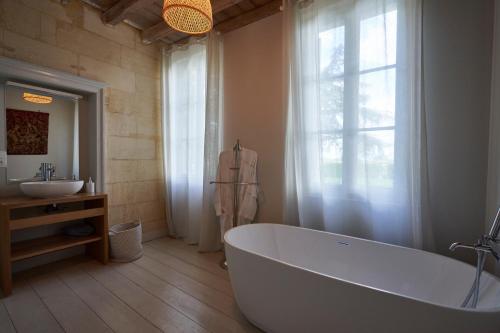 a bathroom with a large tub and a sink at Château Bonalgue - Pomerol in Libourne