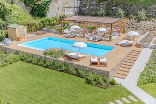 un patio trasero con piscina y cenador en Diamond Apartments, en Bellagio