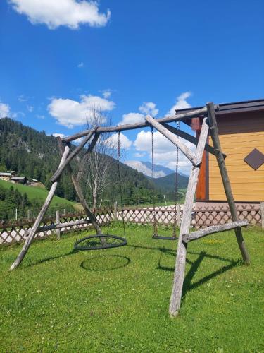a wooden swing set in a field of grass at Biobauernhof Habersatter in Radstadt