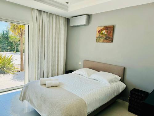 une chambre avec un lit et une grande fenêtre dans l'établissement montechristo, à Saint-Cézaire-sur-Siagne