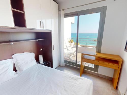 une chambre avec un lit et un bureau et un balcon dans l'établissement Magnifique 3P face mer avec terrasse de 46m² et parking privé - FR-1-196-250, à Menton