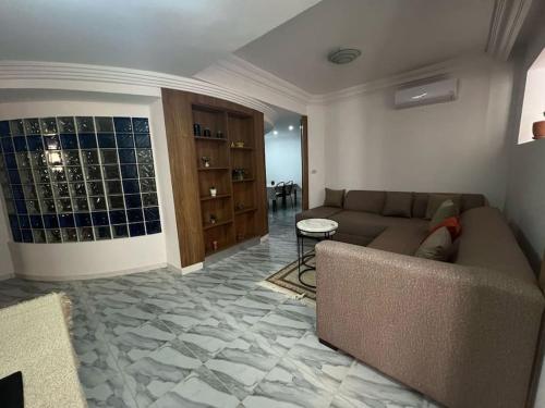 a living room with a couch and a table at une charmante maison a kantaoui in Sousse