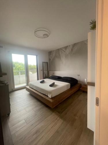 sypialnia z łóżkiem i dużym oknem w obiekcie Attico Sole w mieście Lido di Jesolo