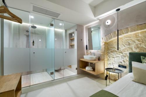 a bathroom with a glass shower and a sink at Monk Rooms in Chania Town