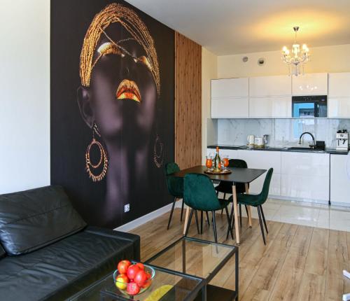a living room with a couch and a table and a kitchen at Apartament Królowej Nilu in Katowice