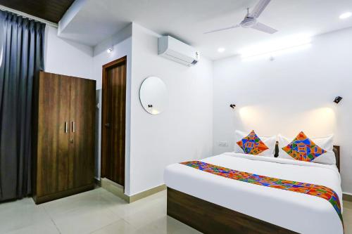 a bedroom with a large bed and a wooden cabinet at FabHotel VK's in Hyderabad
